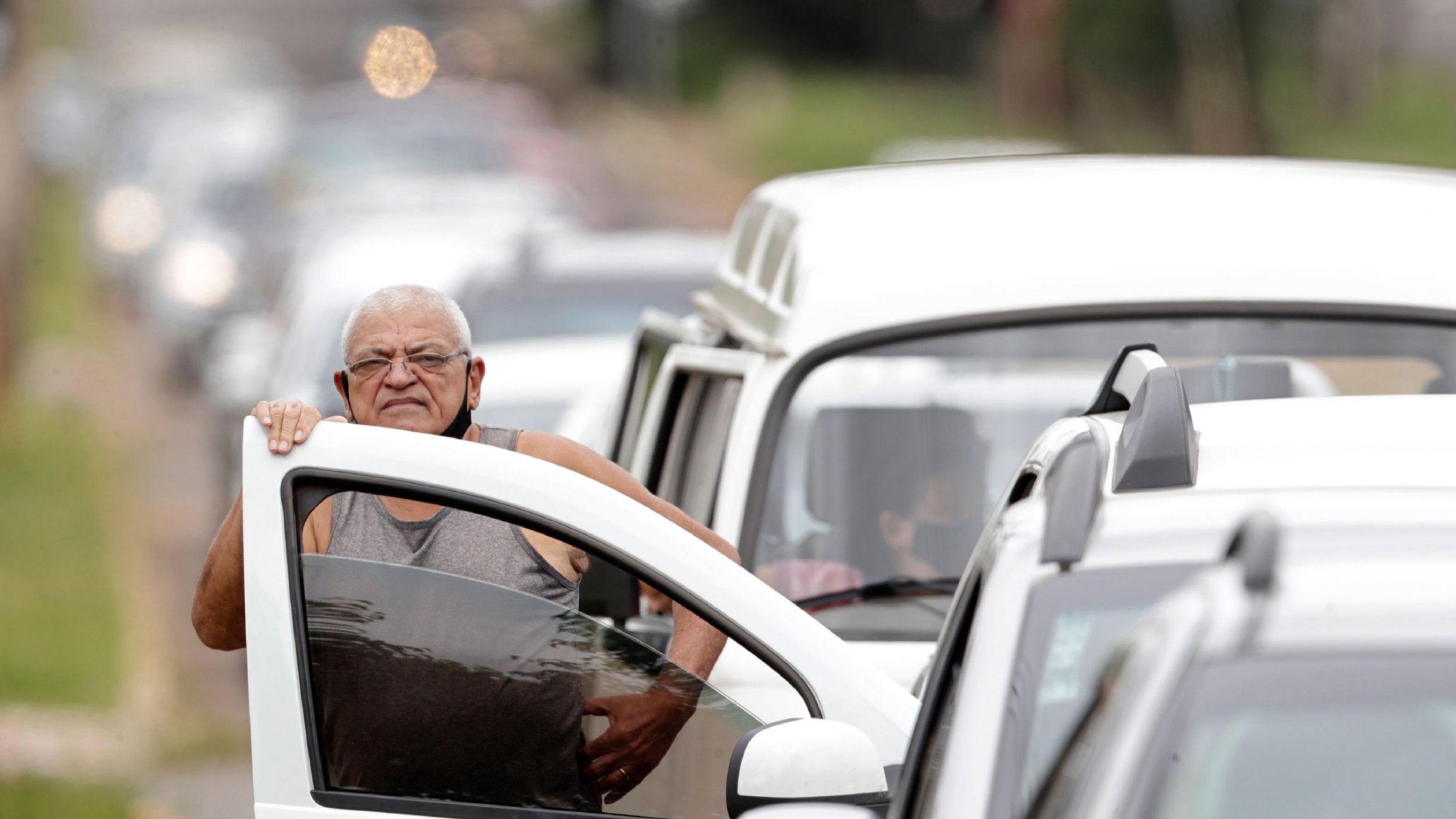 In this March 22, 2021 file photo, a man stands next to his vehicle in a line at a COVID-19 vaccination point for priority elderly persons in the Ceilandia neighborhood, on the outskirts of Brasilia, Brazil. In this March 22, 2021 file photo, a man stands next to his vehicle in a line at a COVID-19 vaccination point for priority elderly persons in the Ceilandia neighborhood, on the outskirts of Brasilia, Brazil.