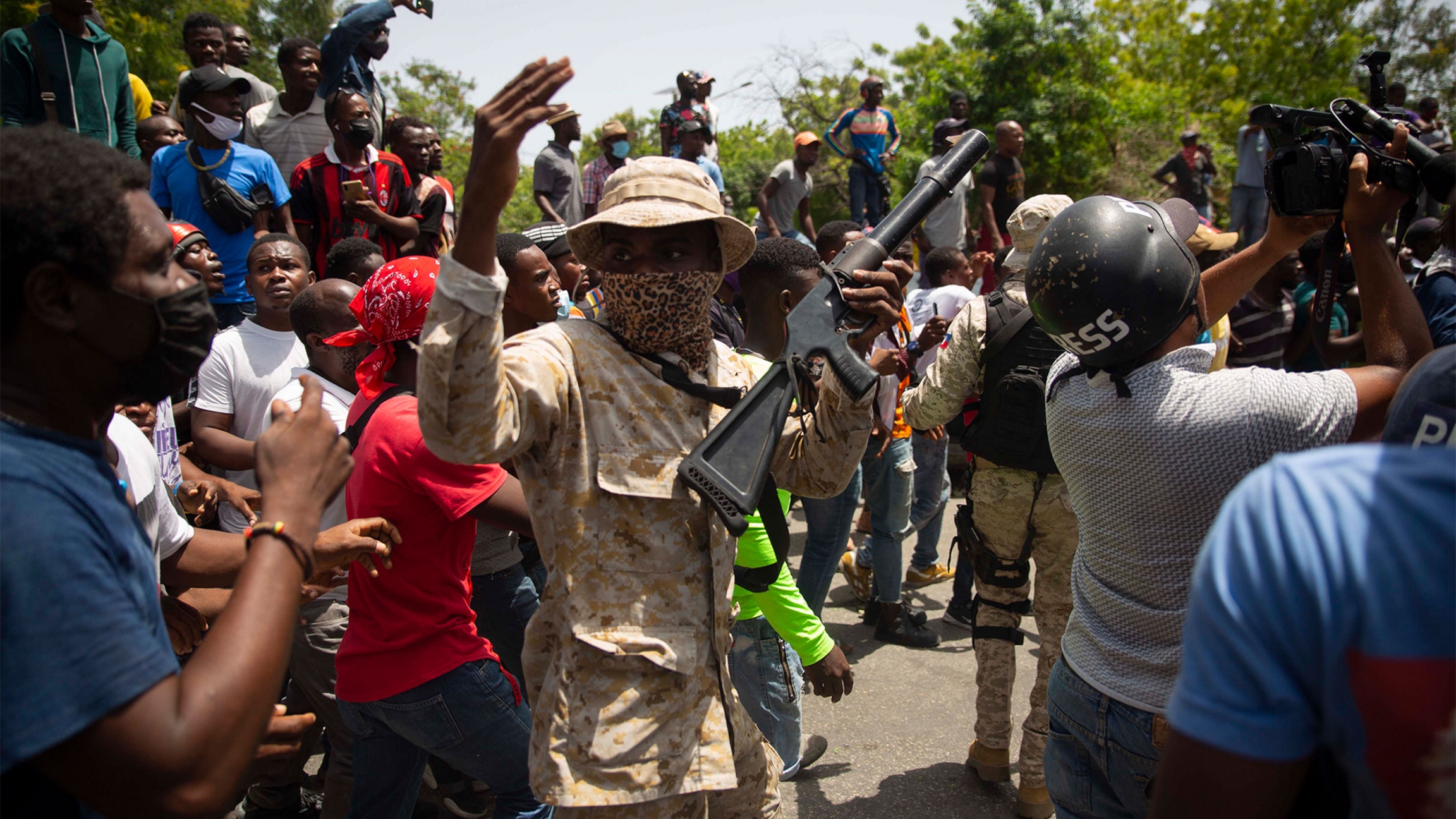 Police stand amid a crowd protesting against the assassination of Haitian President Jovenel Moïse Police in camouflage stand amid a crowd protesting against the assassination of Haitian President Jovenel Moïse