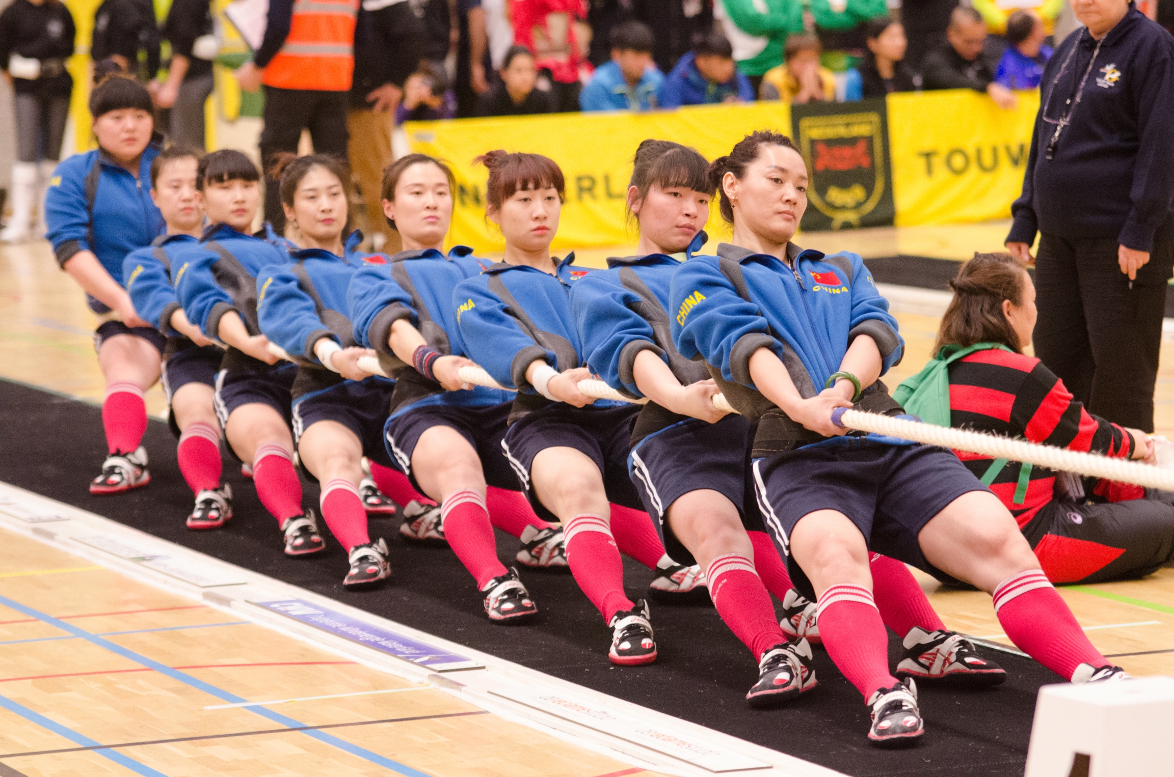 A team of women from China compete in a tug of war competition. A team of women from China compete in a tug of war competition.