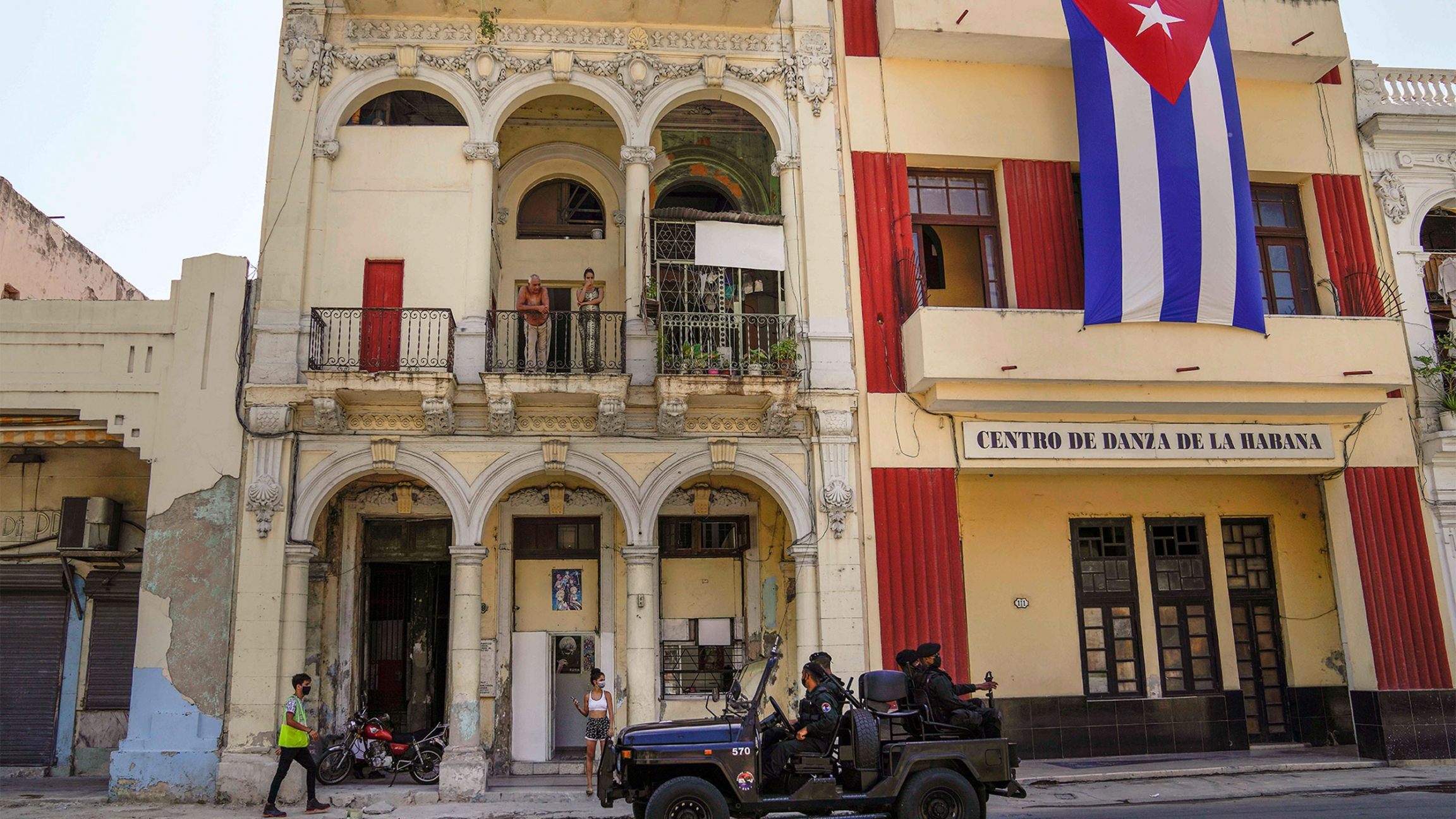 Special forces police patrol the streets as they drive past a large Cuban flag hanging from the facade of a building, in Havana, Cuba Special forces police patrol the streets as they drive past a large Cuban flag hanging from the facade of a building, in Havana, Cuba