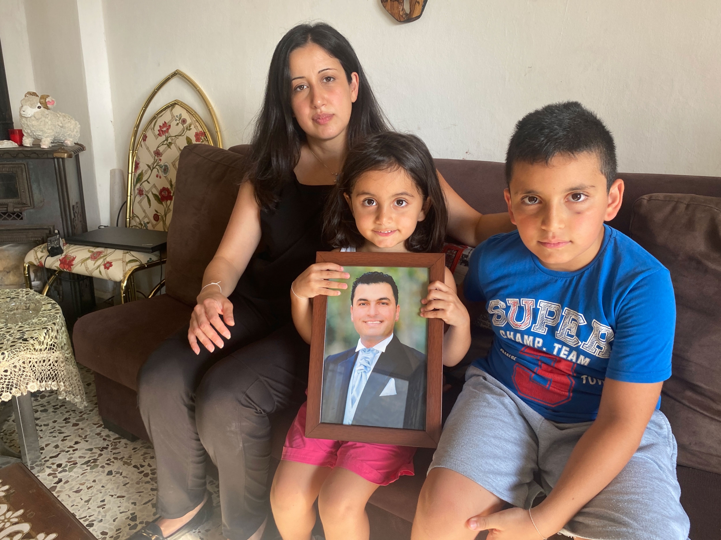 Bernadette Daw Gamayel with her two children and a photo of her husband, Jack, who died in the blast. Bernadette Daw Gamayel with her two children and a photo of her husband, Jack, who died in the blast.