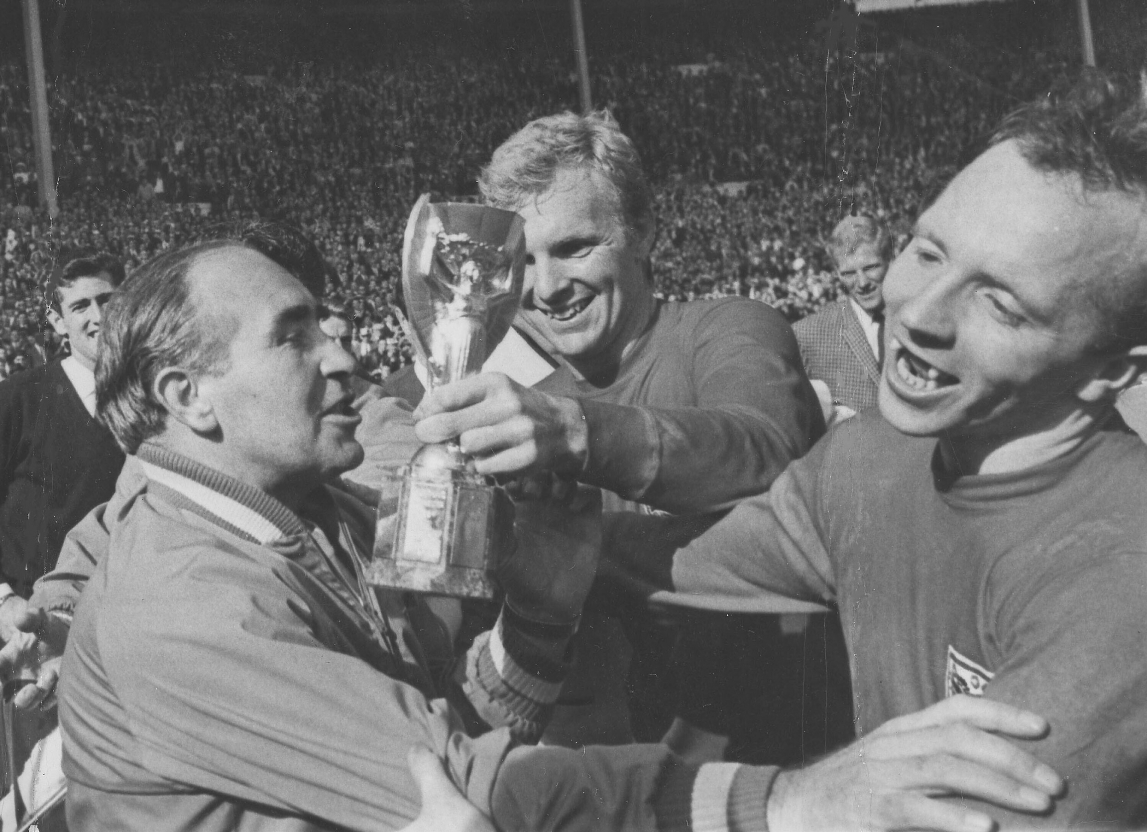 In this July 30, 1966 file photo, England midfield player Nobby Stiles, right, looks at the Jules Rimet Cup, held by England captain Bobby Moore after they had won the World Cup Final at Wembley, London. In this July 30, 1966 file photo, England midfield player Nobby Stiles, right, looks at the Jules Rimet Cup, held by England captain Bobby Moore after they had won the World Cup Final at Wembley, London.