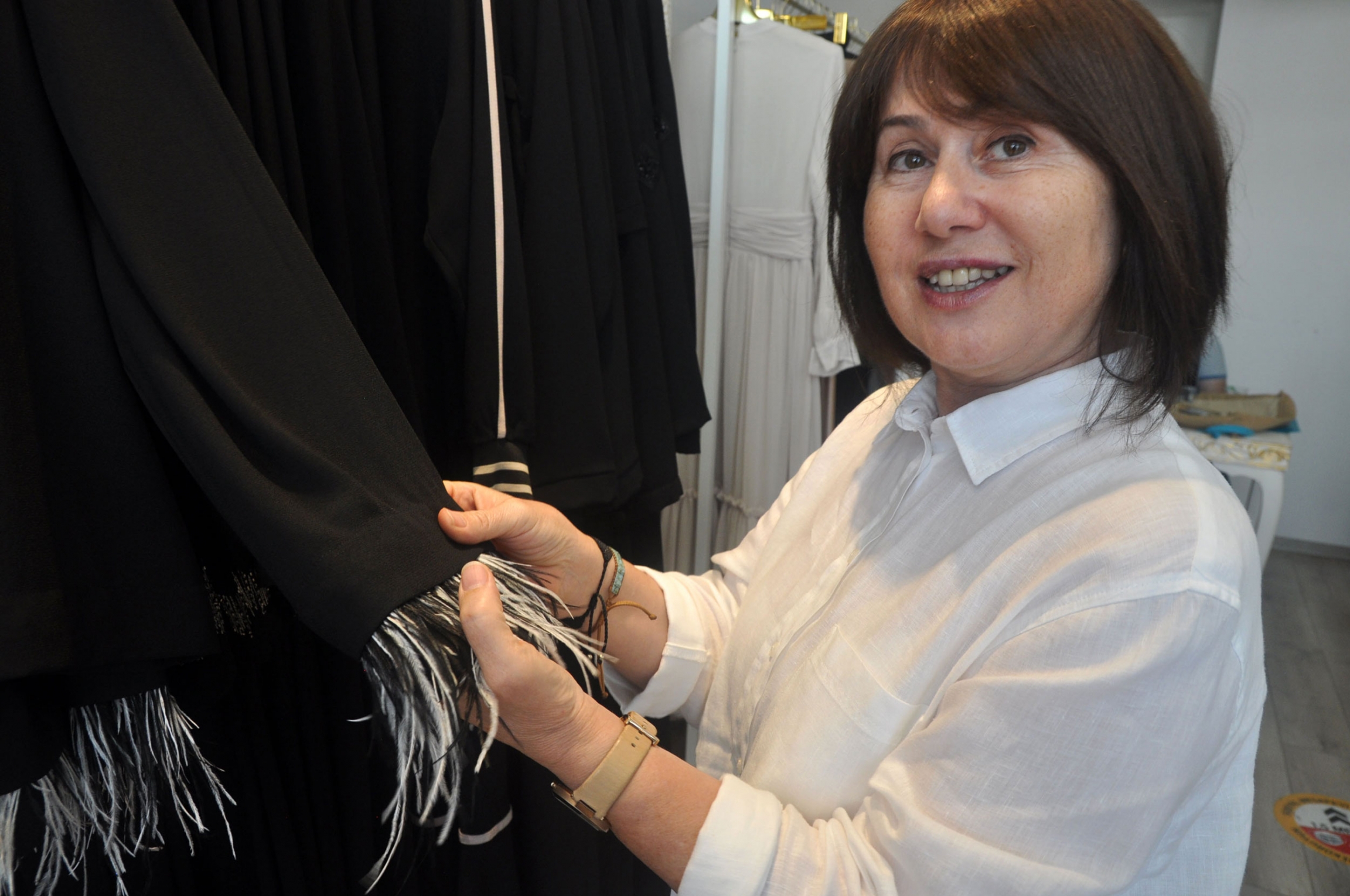 Ayşe Yıldırım explains a detail on one of her designs: a feathered, removable cuff. Pieces that can be worn more than one way are popular in her store, which sells clothes for women who dress modestly. Ayşe Yıldırım explains a detail on one of her designs: a feathered, removable cuff.