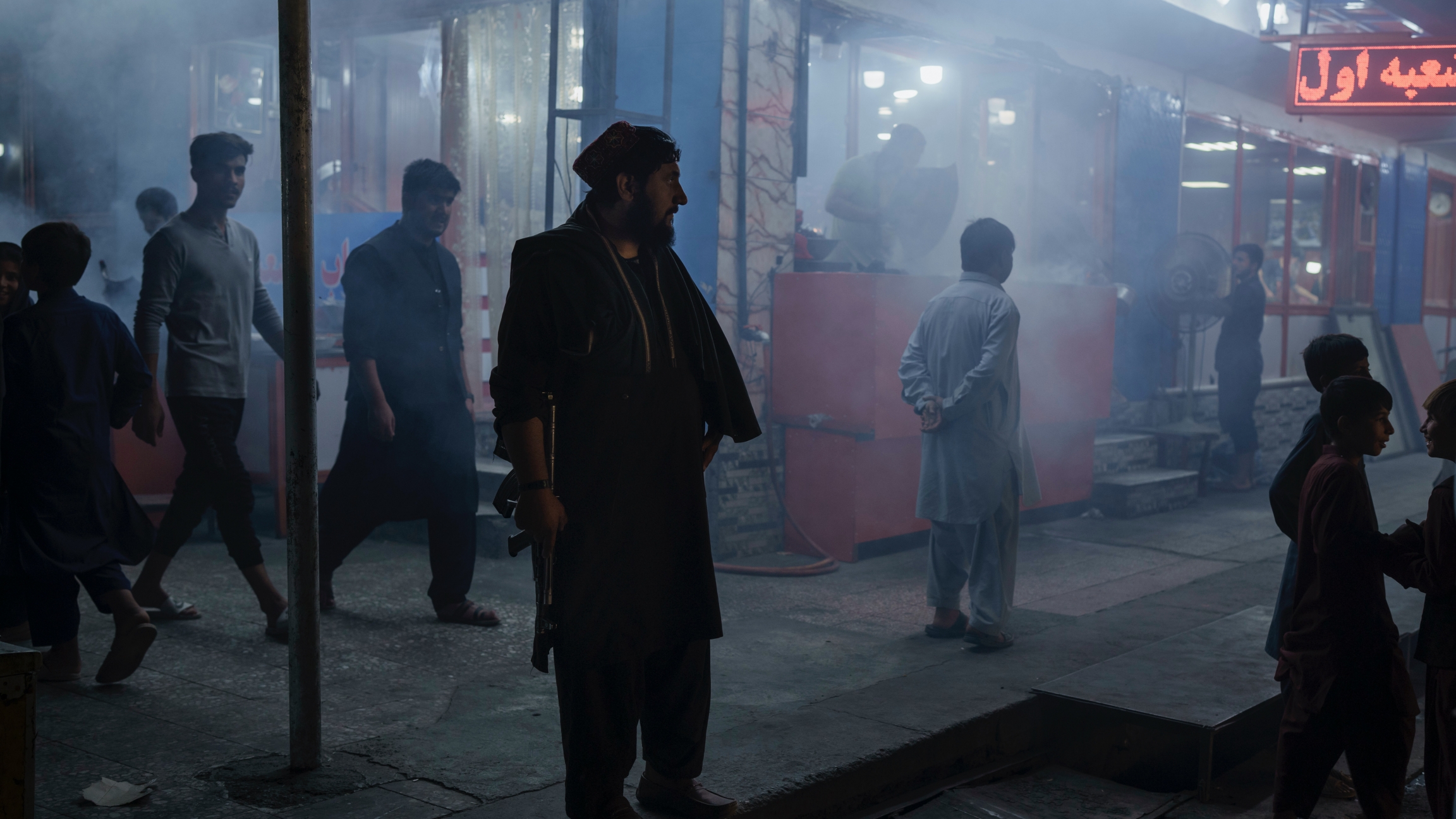 A Taliban fighter stands in the corner of a busy street at night in Kabul, Afghanistan, Sept. 17, 2021. A Taliban fighter stands in the corner of a busy street at night in Kabul, Afghanistan, Sept. 17, 2021.