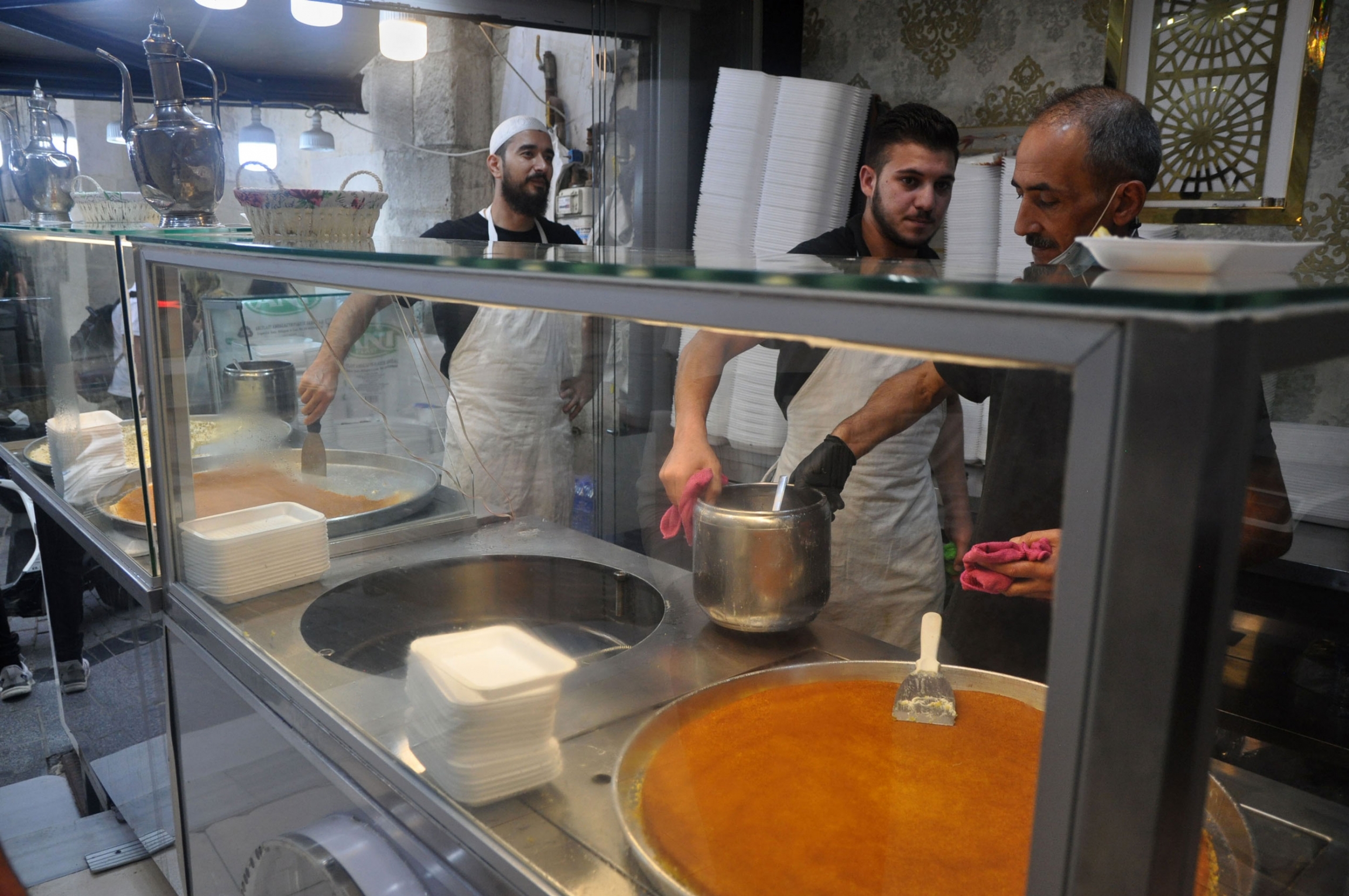 Workers help a customer at a Syrian dessert shop in Istanbul.