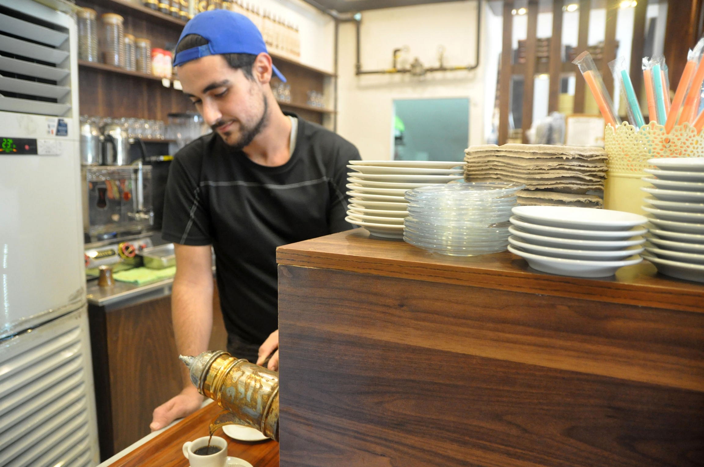 A worker pours a cup of strong coffee at a Syrian sweet shop in Istanbul. Unemployment rates in Turkey are high, and the pandemic affected Syrian workers particularly severely. A worker pours a cup of strong coffee at a Syrian sweet shop in Istanbul. Unemployment rates in Turkey are high, and the pandemic affected Syrian workers particularly severely.
