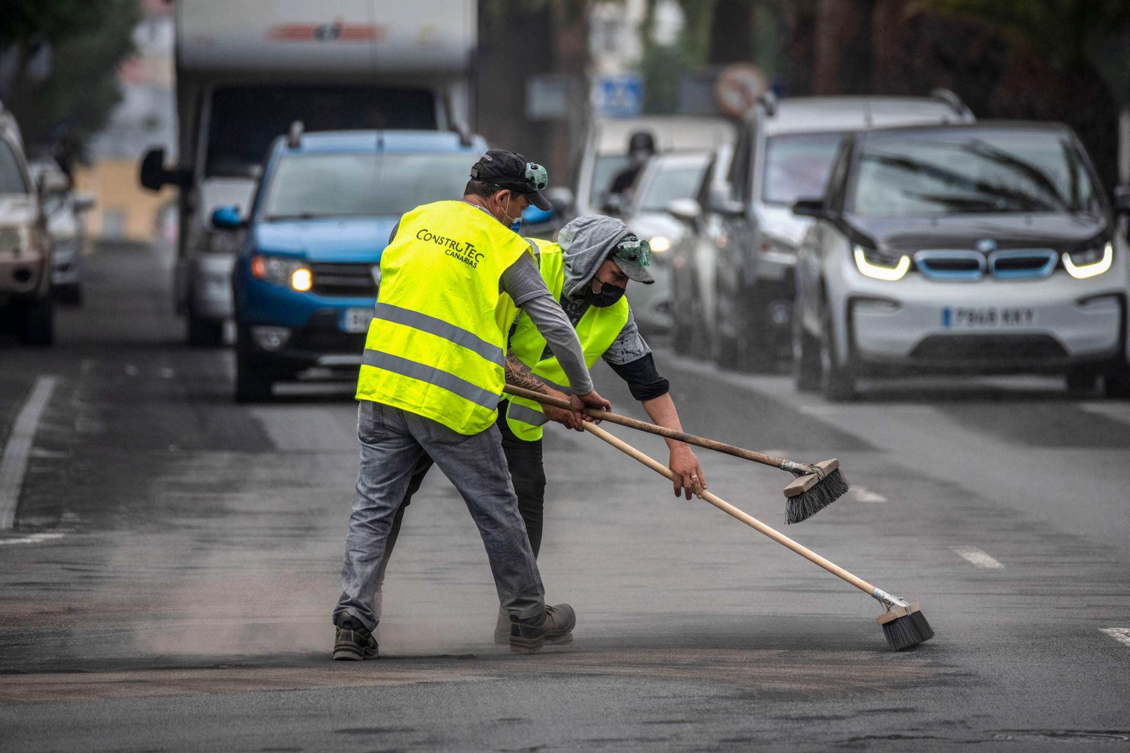 People clean the street covered with ash from a volcano on the Canary Island of La Palma, in Los Llanos de Aridane, Spain on Friday, Oct. 1, 2021. People clean the street covered with ash from a volcano on the Canary Island of La Palma, in Los Llanos de Aridane, Spain on Friday, Oct. 1, 2021.