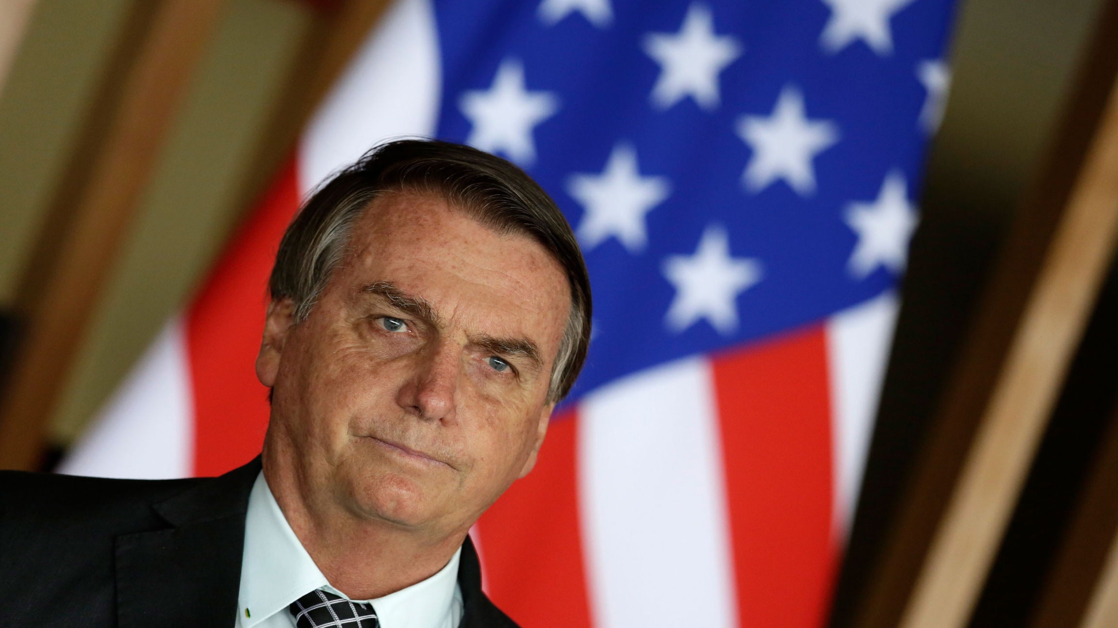 Brazil's President Jair Bolsonaro stands in front of a US flag during a news conference at Itamaraty Palace in Brasilia, Brazil, Tuesday, Oct. 20, 2020. Brazil's President Jair Bolsonaro stands in front of a US flag during a news conference at Itamaraty Palace in Brasilia, Brazil, Tuesday, Oct. 20, 2020.