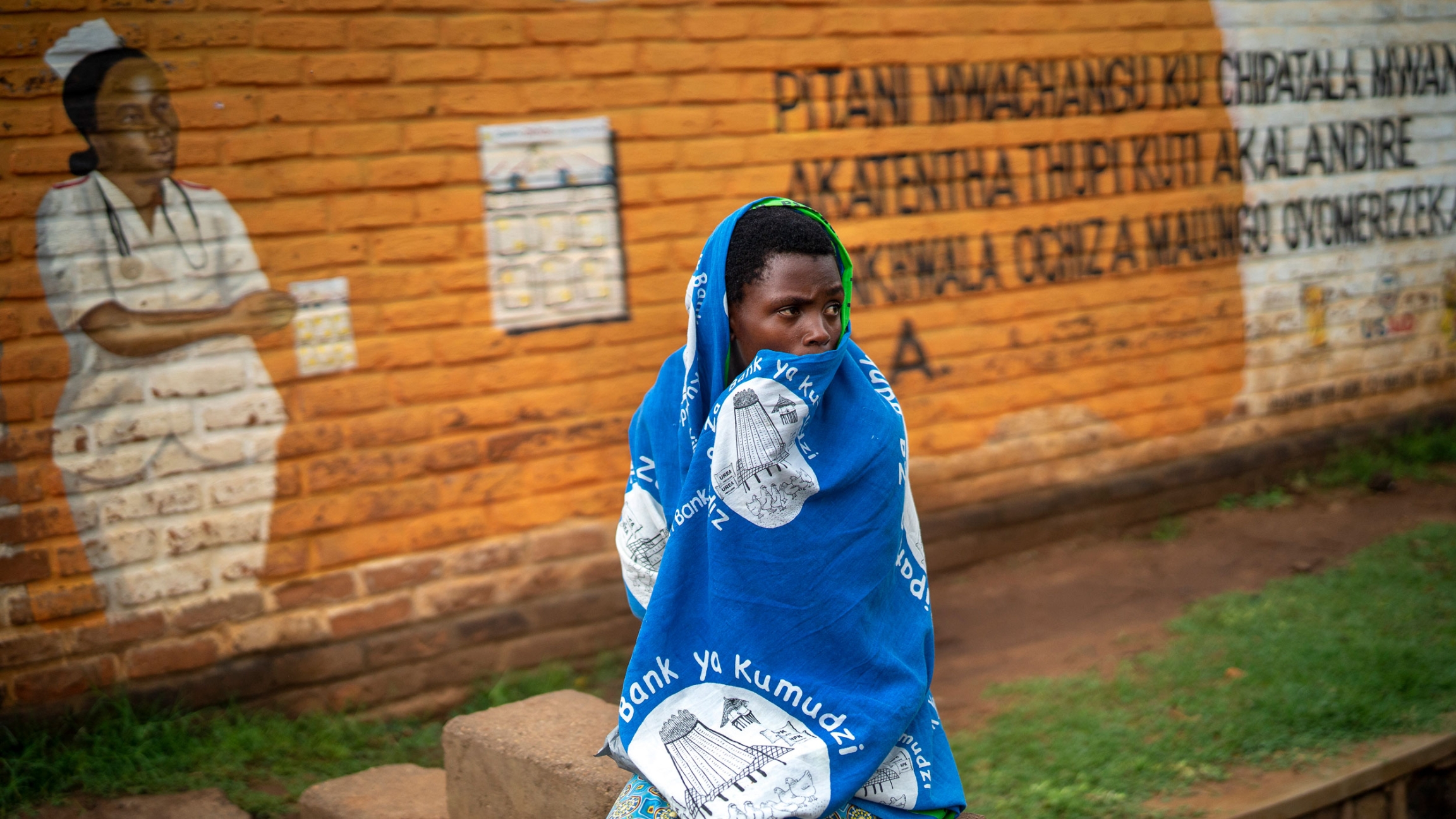 In this Tuesday, Dec. 10, 2019, file photo, a woman waits outside the Migowi Health Clinic to be injected with the world's first vaccine against malaria in a pilot program, in Migowi, Malawi. In this Tuesday, Dec. 10, 2019, file photo, a woman waits outside the Migowi Health Clinic to be injected with the world's first vaccine against malaria in a pilot program, in Migowi, Malawi.