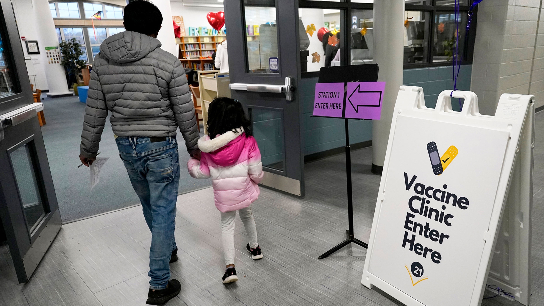 An information sign is displayed as a child arrives with her parent to receive the Pfizer COVID-19 vaccine for children 5 to 11-years-old at London Middle School in Wheeling, Ill An information sign is displayed as a child arrives with her parent to receive the Pfizer COVID-19 vaccine for children 5 to 11-years-old at London Middle School in Wheeling, Ill