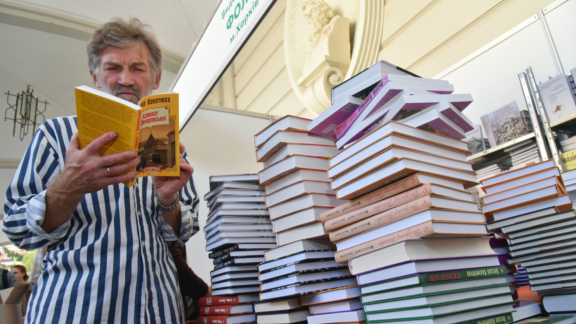 man near stack of books