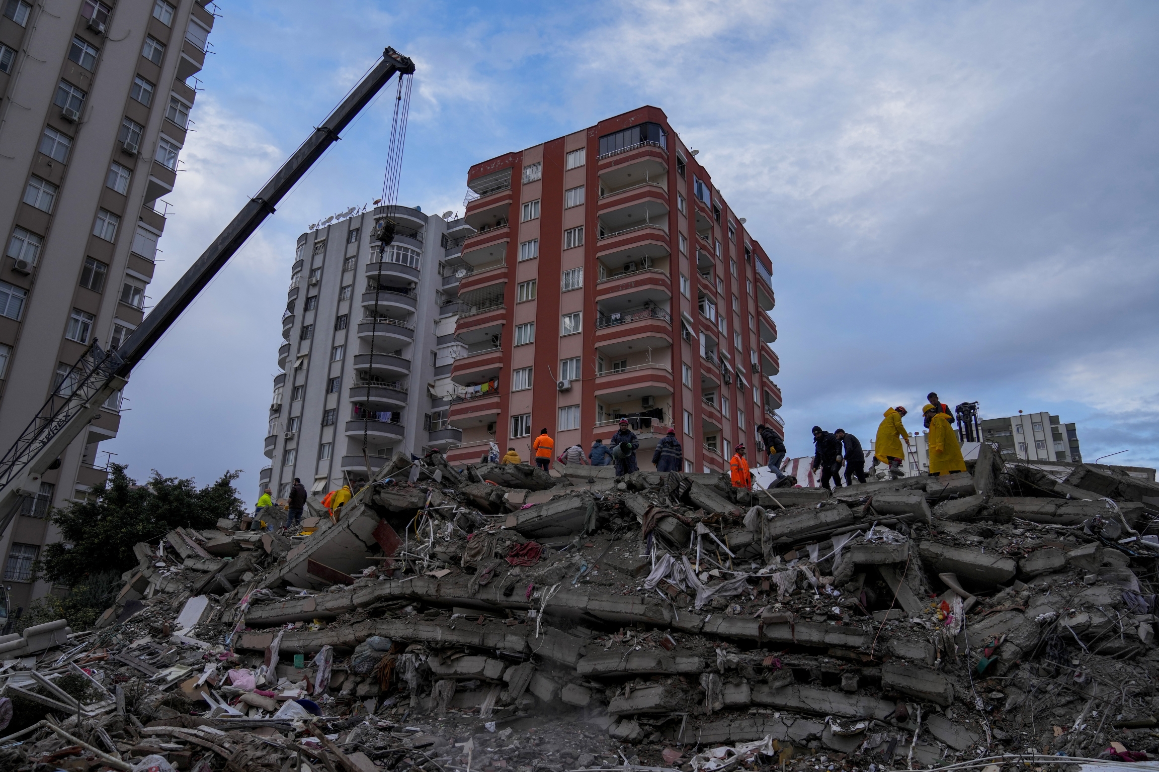 Emergency teams search for people in a destroyed building in Adana, Turkey, after a powerful quake knocked down multiple buildings, Feb. 6, 2023.