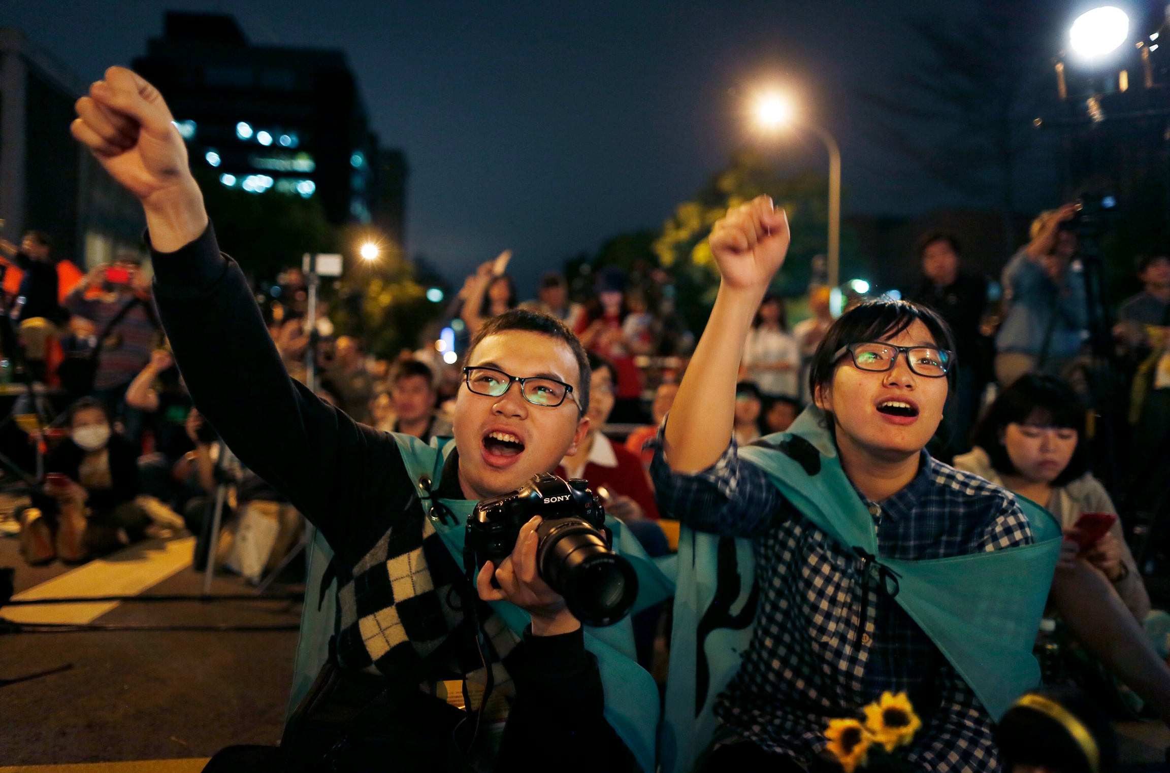 Students cheer on speakers during a gathering to mark the first anniversary of student groups stormed the parliament in Taipei, Taiwan, Wednesday, March 18, 2015. 