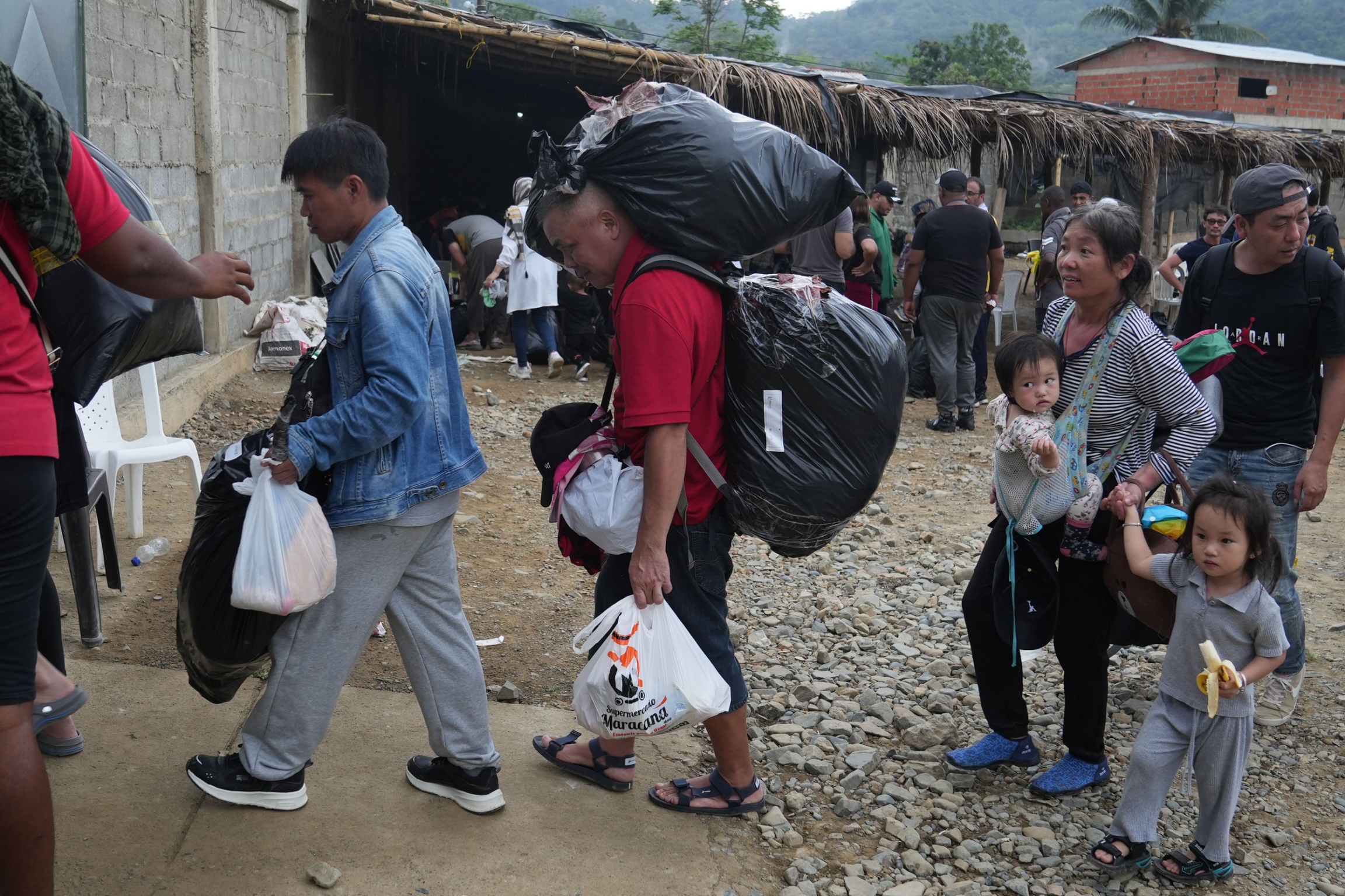 Chinese migrants leave the shelter in Capurgana, and prepare to take a speedboat that will take them to a village in Panama. 