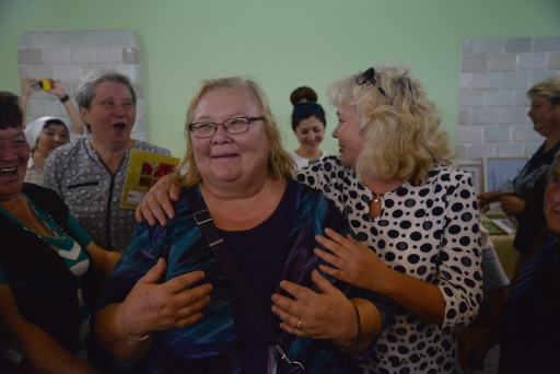 Woman surrounded by people, crying and laughing