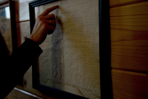 Woman's finger pointing at scroll on wall