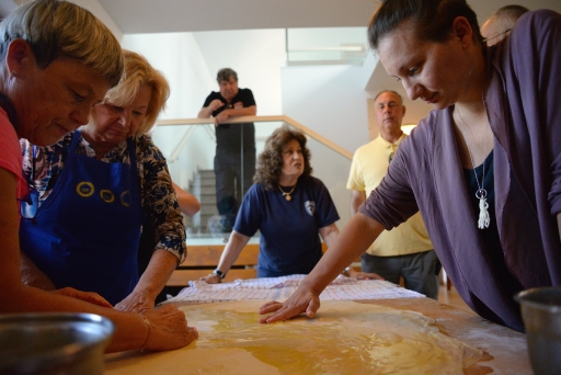 Women stand around table, cooking