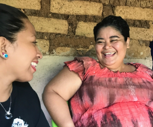 two women facing each other, laughing
