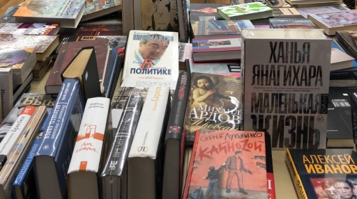 Russian Language books Dozens of books in Russian are on display on a table inside a bookstore.