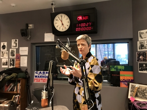 Vestager speaking about EU regulations. A women speakers into a microphone inside a recording studio.