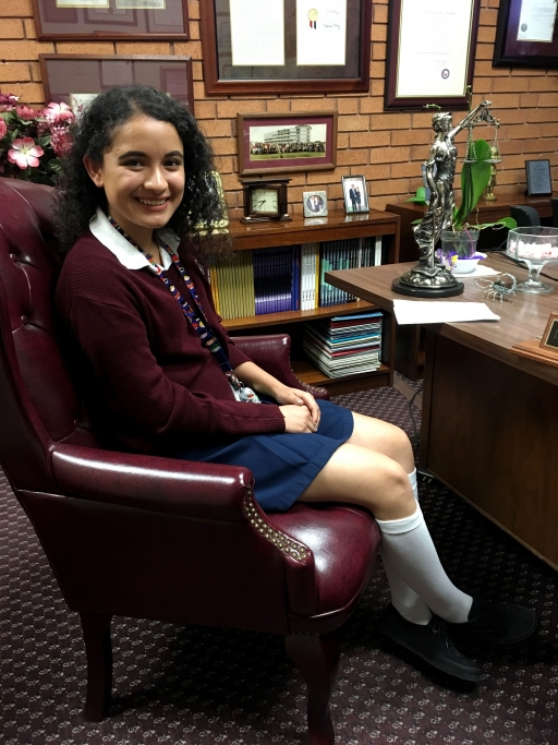 A girl in a school uniform poses for a photo