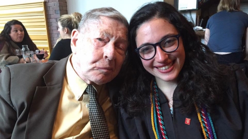 An older man and a young woman pose for a photo