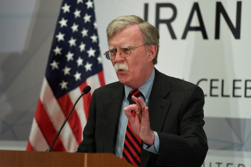 A man speaks at a podium with the US flag to one side.