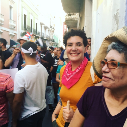 Several people smile at the camera while in a crowd