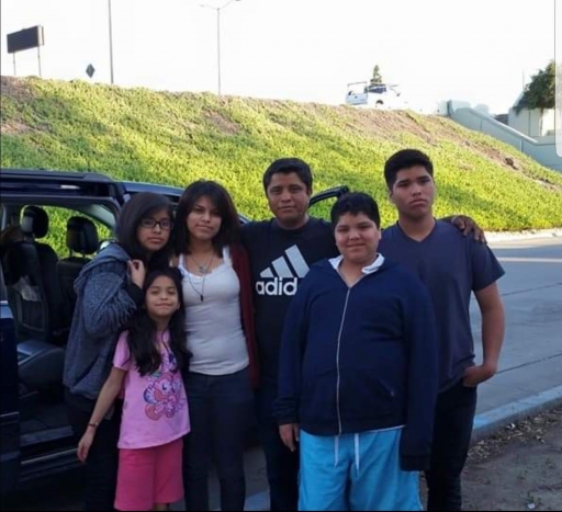 Hugo González Velasco, center, poses with his children in Tijuana in 2015. That was the last time the children saw their father all together. A family stands in front of car near a green hill