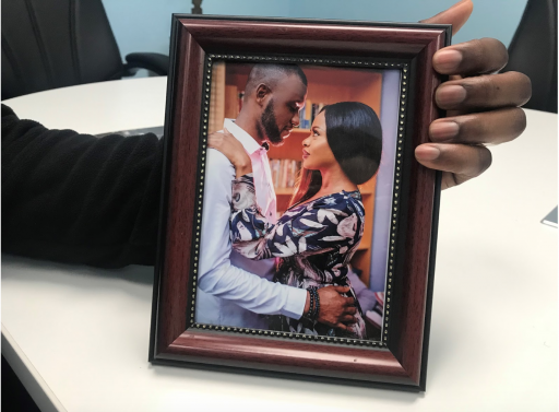 Saheed and Azeeza A man holds a framed photo of a couple