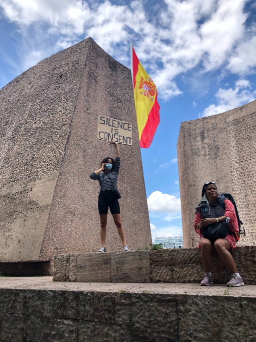 Two protesters attend the George Floyd memorial and one holds a sign that says "silence is consent," on June 7, 2020, Madrid, Spain. Protesters, one holds a sign reading "silence is consent."