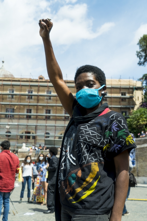 Beatmaker and producer Karima 2G at the Black Lives Matter protest in Rome, Italy, June 7, 2020. A Liberian woman with short afro wears a blue face mask at a protest