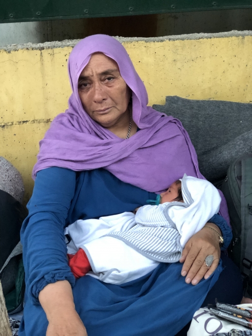 Fatima, a 66-year-old asylum-seeker from Afghanistan, cradles her 1-month-old grandchild after they were displaced by a fire in Lesbos' Moria camp. Fatima, a 66-year-old asylum-seeker from Afghanistan, cradles her one-month-old grandchild after they were displaced by a fire in Lesbos' Moria camp.