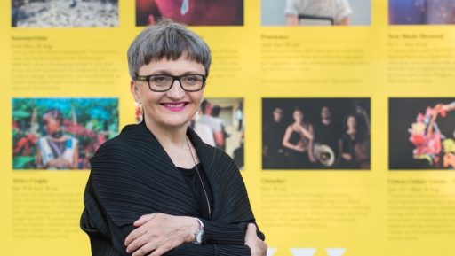 Gillian Moore, director of music at the Southbank Centre, which includes the Royal Festival Hall. A white woman wearing glasses and a short hair cut smiles in front of yellow backdrop