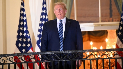 After pulling off his face mask, President Donald Trump poses atop the Truman Balcony of the White House following hospitalization at Walter Reed Medical Center, Oct. 5, 2020.