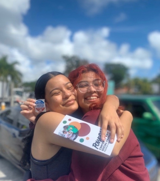 Yaneilys “Pink” Ayuso (right) and best friend, Thais Maradiaga (left) are first-time voters from Miami, Florida. Two young people embrace each other and show an "I voted" sticker