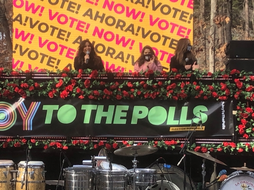 Left to right are actors Eva Longoria, America Ferrera and Kate del Castillo. Actors sit on a panel in front of a large yellow and red sign that says vote.