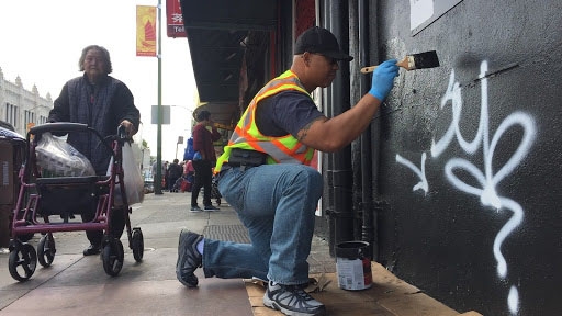 Community ambassador Sakhone Lasaphangthong helps paint a storefront in Oakland’s Chinatown. Community ambassador Sakhone Lasaphangthong helps paint a storefront in Oakland’s Chinatown.