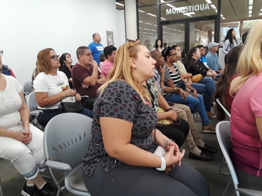 Cuban Americans call on Biden administration to help reunite their families. Group of Cuban Americans sitting on chairs at a meeting
