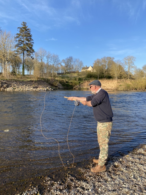Malcom Campbell is a lifelong Scottish independence supporter and professional fisherman. Malcom Campbell leans over the river with a fishing line on a sunny day.