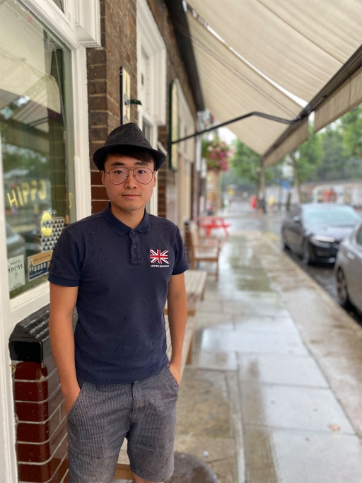 Simon Cheung, exiled Hong Konger pro-democracy activist now living in London Man stands wearing a hat and a dark blue shirt with a UK flag on it