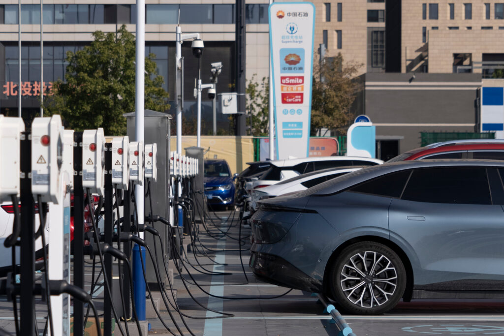 Electric vehicles plugged into a row of charging stations at a PetroChina supercharging facility in China
