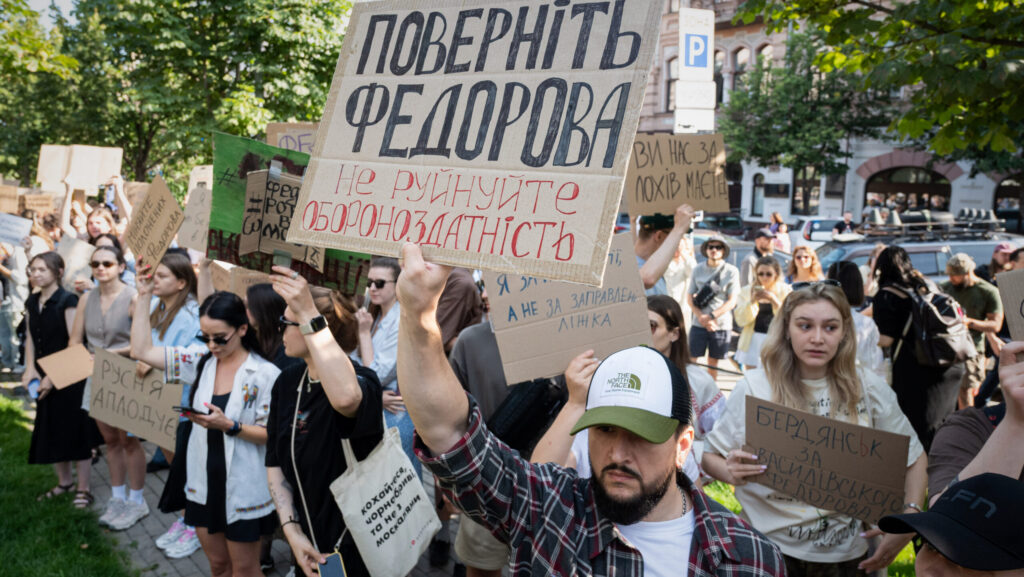 Protesters holding handmade signs in Ukrainian, including one reading "Bring back Fedorov, don't destroy defense capability," at an outdoor rally